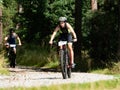 Female biker hold possition through long gravel descent in forest