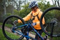 Female biker repairing mountain bike