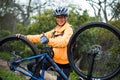 Female biker showing thumbs up while repairing mountain bike Royalty Free Stock Photo