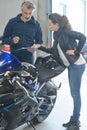 Female biker talking to mechanic