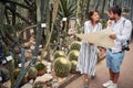 Female biologist explaining map to a male tourist in botanical garden