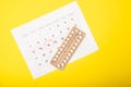 Female birth control pills and calendar on a yellow background Royalty Free Stock Photo