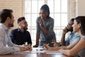 Female black executive talking to diverse employees at office briefing