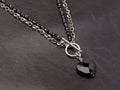 Female black heart shaped agate pendant with silver agate chain on brown leather