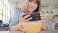 Female blogger photographing green tea cup in cafe with her phone. A young woman taking photo of coffee tea on smartphone, Royalty Free Stock Photo