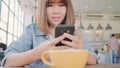 Female blogger photographing green tea cup in cafe with her phone. A young woman taking photo of coffee tea on smartphone, Royalty Free Stock Photo