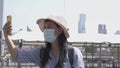 A female blogger is taking a selfie with landmark Bangkok. Influencers wearing masks are narrating and live. While touring and