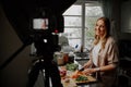 Young female blogger vlogger and online influencer recording video content on healthy food Royalty Free Stock Photo