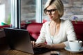 Female Blogger Wearing Glasses While Using Laptop In Cafe