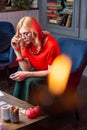 Female blonde astrologist sitting at the table with burning candles