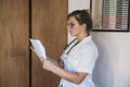 Woman doctor reading papers in office Royalty Free Stock Photo