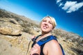 Female blonde hiker spots to squit to look off into the distance