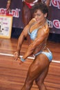 Female bodybuilder in chest pose with blue bikini