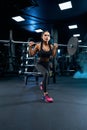 Female bodybuilder doing lunges using barbell in gym. Royalty Free Stock Photo