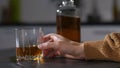 Female boozer`s hand pouring alcohol into glass