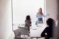 Female Boss Gives Presentation To Team Of Young Businesswomen Meeting Around Table In Modern Office Royalty Free Stock Photo