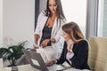 Female boss showing documents to personal assistant giving instructions and tasks