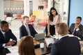 Female boss stands listening to colleagues at team meeting Royalty Free Stock Photo