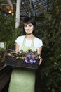 Female Botanist Carrying Crate Full Of Flower Plants