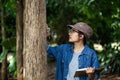 Female botanists are looking at the bark of trees to make notes for researches on the environment. Climate change and save the ear