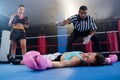 Female boxer looking while referee counting by athlete Royalty Free Stock Photo