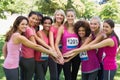 Female breast cancer marathon runners stacking hands Royalty Free Stock Photo