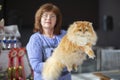 A female breeder holds a pet at a cat show