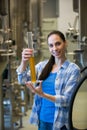 Female brewer holding hydrometer cylinder