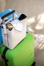 Female bright travel baggage with green suitcase and white handbag at international airport terminal