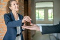 Female broker giving the key to the buyer