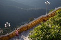 Female buddhist monk walking down the stairs. Nun wears traditional pink and orange clothes, shaved head. Kyaiktiyo pagoda Golden