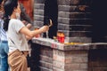 Female Buddhist worshiper burning incense near a Buddhist temple in Vietnam