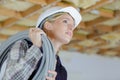 Female builder carrying cable on shoulder