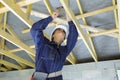 Female builder hammering roof beam