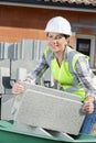 female builder lifting concrete block