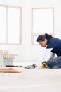 A female builder measuring a plank of wood