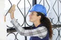 Female builder worker polishing metal barrier Royalty Free Stock Photo