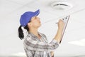 female building inspector looking light in ceiling Royalty Free Stock Photo