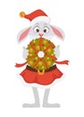 Female bunny in Christmas hat and skirt holds festive wreath