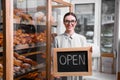 Female business owner holding OPEN sign Royalty Free Stock Photo