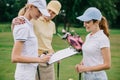 female business partners with notepad discussing project during golf game Royalty Free Stock Photo