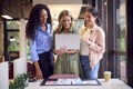 Female Business Team With Laptop At Desk In Modern Office Approving Proofs Or Design Layouts Royalty Free Stock Photo