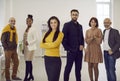 Happy confident businesswoman standing in the office with a team of employees in the background Royalty Free Stock Photo