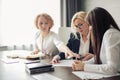 Female business team of attractive employees discuss online project in office. Royalty Free Stock Photo