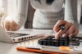 Female businessman calculates financials with graph paper on the laptop computer on the cost of home office Royalty Free Stock Photo