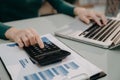 Female businessman working on desk office with using a calculator to calculate and business report on office desk, finance Royalty Free Stock Photo