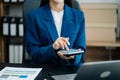 Female businessman working with holding a pen and using a calculator to calculate the numbers of static at home office. Finance Royalty Free Stock Photo