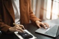 Female businessman working with holding a pen and using a calculator to calculate the numbers of static at home office. Finance Royalty Free Stock Photo