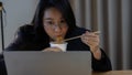 Female businesswoman, manager, employee is eating instant noodles during late work at midnight