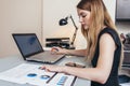 Female businesswoman readind financial report analyzing statistics pointing at pie chart working at her desk Royalty Free Stock Photo